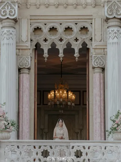 The bride appearing on the balcony of the magnificent Ciragan Palace in Istanbul. This shot captures a sense of royal grandeur and anticipation, a truly cinematic moment.