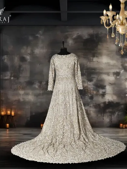 Elegance personified in our beige net Indo-Western bridal attire, adorned with exotic stones, mirrors, pearls, and intricate zardozi work.