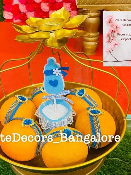 This golden basket contains decorated coconuts with a blue baby bottle cutout, another one of my custom designs for baby-related functions.