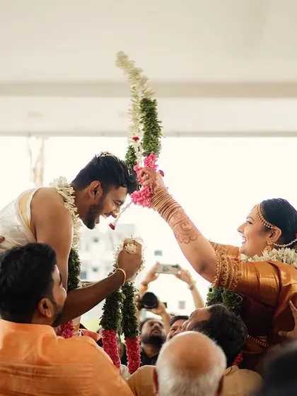 A joyful moment during the garland exchange, where the couple is lifted up by their families. It's a fun, competitive ritual that I love to capture for its energy and laughter.