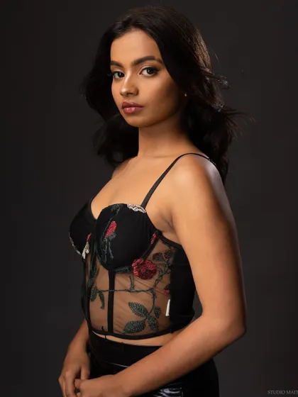 A classic three-quarter portrait of a model in a floral corset top.