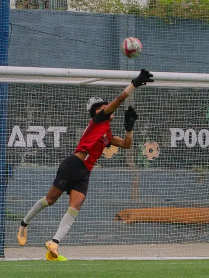 A goalkeeper in full flight during a training session, demonstrating the agility and technique we develop. Our specialized goalkeeping program focuses on every aspect of the position.
