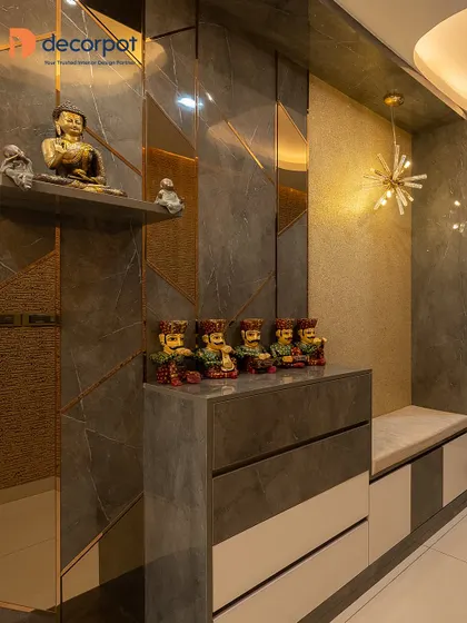 This luxurious foyer features a marble-clad partition with gold inlays and a built-in seater. The design includes display shelves for decor, creating a glamorous and functional entryway.