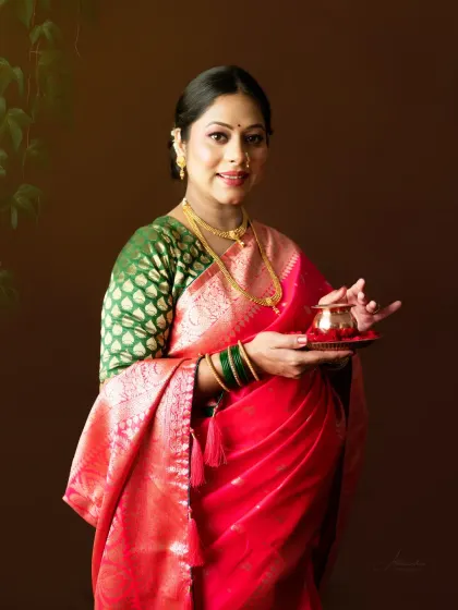 A classic close-up portrait. The mom-to-be holds a small, traditional pot, and her warm smile radiates joy. The focus is on her and her beautiful attire.