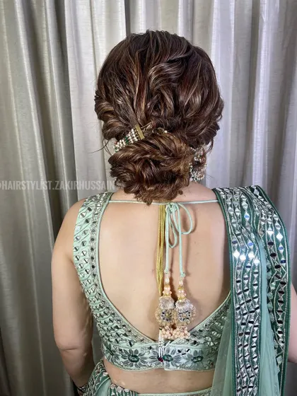 I created this textured low bun for a sangeet night, weaving in a traditional jeweled accessory. The highlights in the hair add depth to the twists and folds of the updo.
