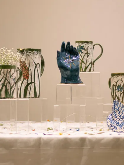 A stunning display of sgraffito mugs and a sculptural hand piece by Vanessa Anthony at our student exhibit.