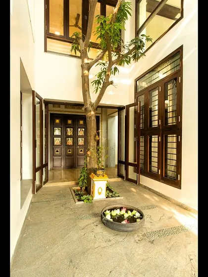 The heart of the Eco Terre home is this internal courtyard with a live tree growing through two floors, centered around a traditional Tulasi madam.
