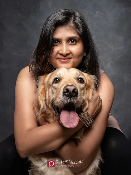 A warm hug and a big smile. This studio portrait beautifully captures the loving bond between a pet parent and her Golden Retriever.