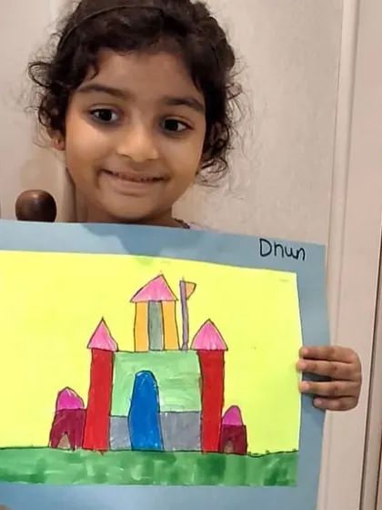 A close-up of this young artist and her colorful castle. Her happy and confident smile is the result of creating something from a blank page all by herself.