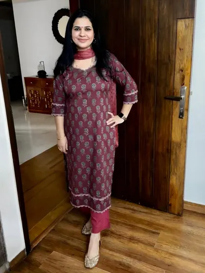 A straight-cut kurta in a deep maroon block print fabric. The design is enhanced with delicate lace on the neckline, sleeves, and hem for a polished finish.