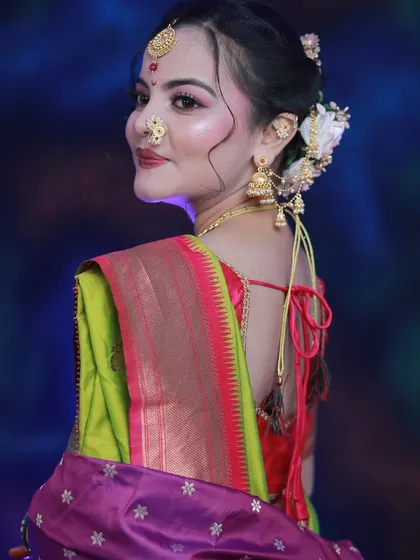 A back view of the student's work, highlighting the elegant floral bun and the perfect draping of the saree.