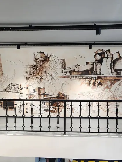 Another view of the architectural tribute mural, showing the detailed line work that captures the essence of famous buildings like the Sagrada Familia and the Guggenheim Museum.