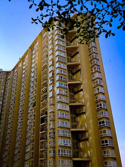 A towering apartment building against a brilliant blue sky. This shot plays with angles and perspective to emphasize the height of the structure.