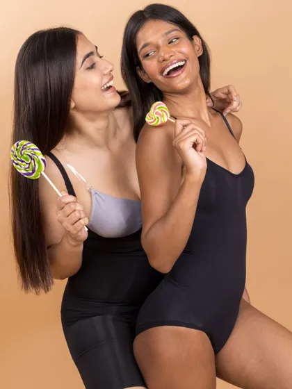 A fun and candid moment from the Skkulpt shapewear shoot. Using lollipops as props adds a touch of playfulness, showing that confidence and style can be joyful.