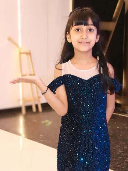 A young girl in a sparkling blue dress strikes a pose at her party. We capture the personality and style of the birthday girl.