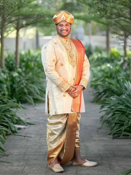 A full-length shot of the groom in his regal wedding attire. The custom-designed Kache Panche set is a true work of art.