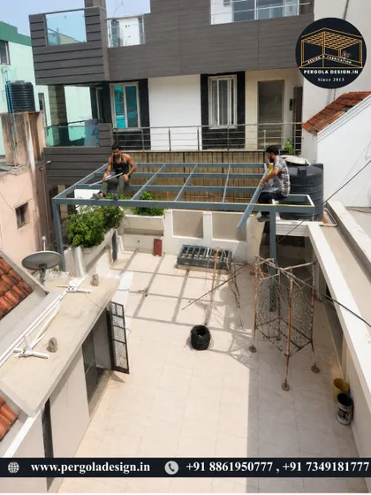 An aerial view of the glass pergola installation. This perspective shows the scale of the project and the precision required to fit the framework into the existing terrace space.