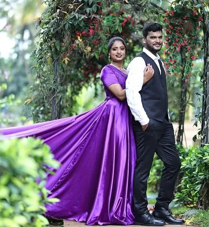 This couple looks elegant in a garden setting. The long trail of the purple flying gown adds a touch of royalty to their pre-wedding photos.