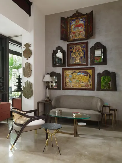 This seating area in the Courtyard Home is a dialogue between different cultures and eras. A contemporary chair from our Koko collection sits beside a rotating Edwardian bookshelf, with a backdrop of traditional Indian art and antique mirrors, showcasing our love for eclectic curation.