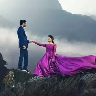 A breathtaking mountaintop pre-wedding shoot. The purple flying gown I provided creates an unforgettable, cinematic image against the misty hills.