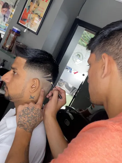 Here I am in the process of creating a detailed hair tattoo. Using a razor, I carefully carve out the lines for a precise and sharp finish.