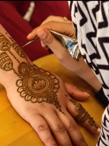 A photo of me in action, creating a lotus and jhumka design. I love this combination of grace and playfulness.