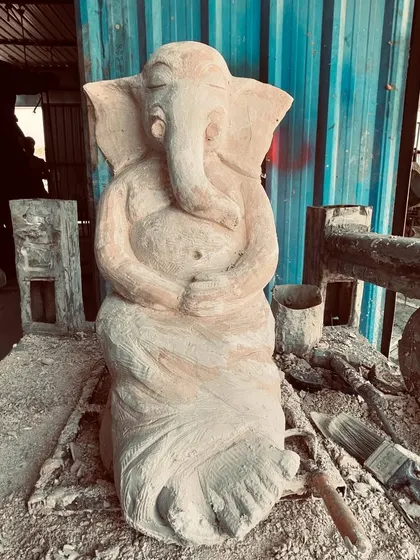 This is a Ganesha sculpture in its early, raw form. After shaping the basic structure, it is left to dry slightly before the intricate carving work begins. You can already see the gentle posture taking shape.