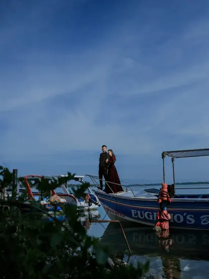 A wide shot of a couple on a boat, showing the grand scale of the sky and water. This kind of environmental portrait is great for telling a larger story.