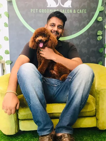 Cookie the poodle is all fluff and smiles, enjoying a cuddle after his grooming. We ensure every pet feels safe and loved.