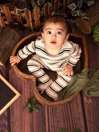 A unique, top-down view of this little one nestled in a heart-shaped wooden bowl, part of our "Wild One" jungle theme.