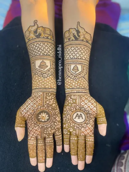 A cute and simple design for a special beginning. This piece features elephant motifs on the arms and the couple's initials on the palm, surrounded by a lotus, perfect for an engagement.