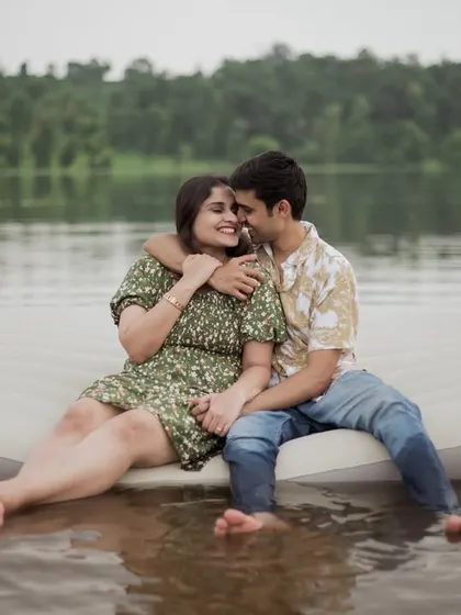 A sweet embrace as the couple sits on the edge of the airbed, with their feet in the water.