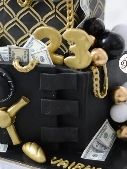The gold numbers and black and gold spheres add to the luxurious feel of this cake.