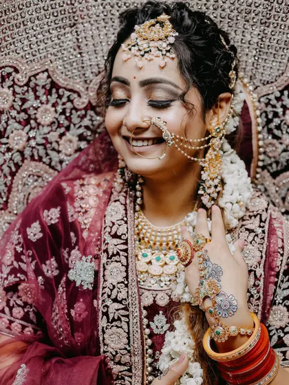 A joyful, smiling portrait of the bride. Her happiness is contagious in this beautiful shot that highlights her natural beauty and elaborate jewelry.