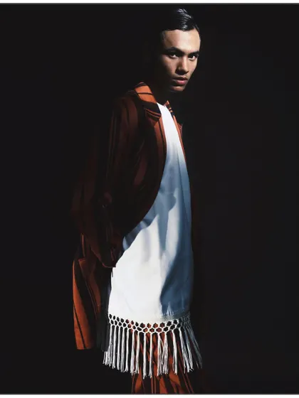 A striking portrait from my 'Silhouette' series, using chiaroscuro lighting to carve the model out of the darkness. This high-contrast technique emphasizes the form of the striped suit and the subject's intense gaze, showcasing my love for dramatic light.