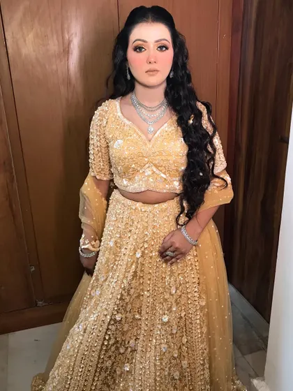 The full view of the golden lehenga and the radiant makeup.