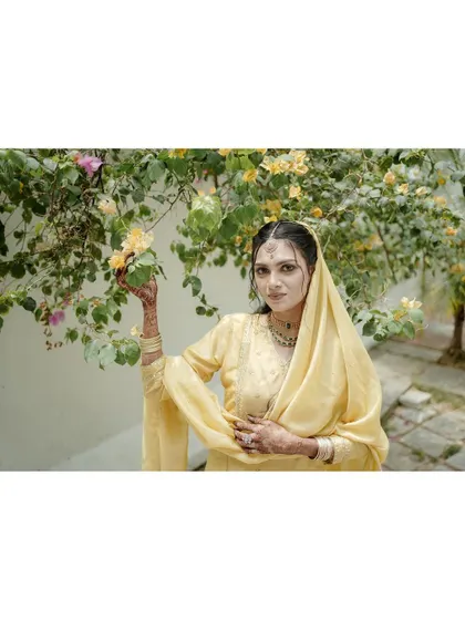 A portrait of the bride amidst blooming flowers, her yellow dress and the natural setting creating a fresh and vibrant image.