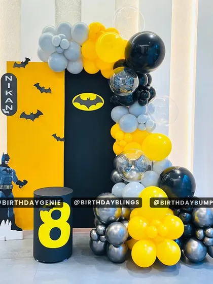A sleek and modern Batman-themed party for an 8th birthday. The black and yellow color scheme, bat-symbol backdrop, and character cutout create a cool, graphic look.