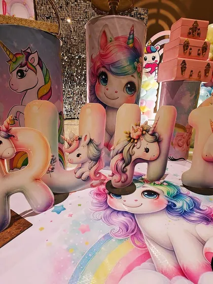Intricately designed 3D letters spelling 'RUHI' for a unicorn-themed first birthday. Each letter is adorned with its own unique unicorn figure, adding a highly personalized and artistic touch.