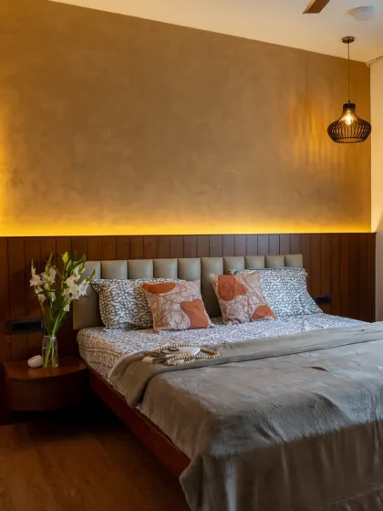 The full view of the master bedroom, where a textured accent wall and integrated headboard lighting create a warm and inviting atmosphere.