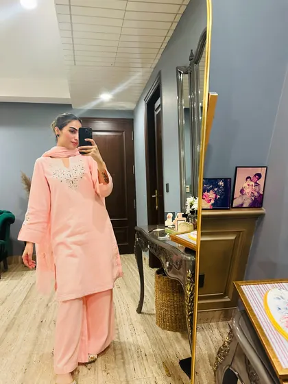 A mirror selfie in a simple and elegant peach-colored suit.