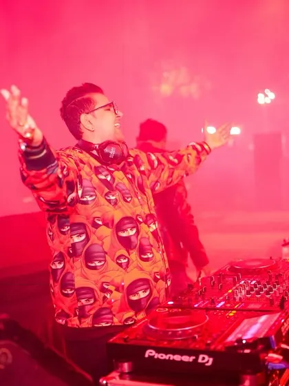 A DJ energizes the crowd, enveloped in red stage lighting and atmospheric smoke. We ensure every performance, from the main act to the DJ set, has the right ambiance and technical support.