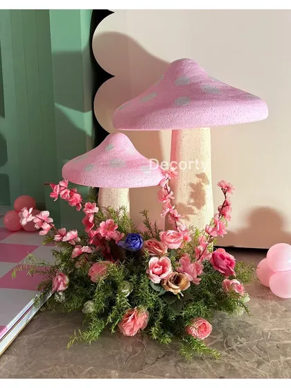 Decorative mushroom props with floral arrangements, enhancing the enchanted forest feel of the party.