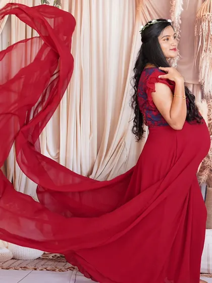 The deep red color and flowing fabric of this maternity gown create a powerful and elegant look. It's a fantastic choice for both indoor studio sessions and outdoor photoshoots.