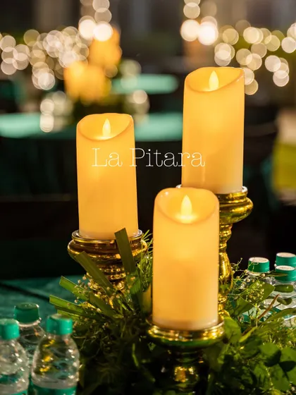 The table centerpieces were simple and elegant, featuring flameless pillar candles on golden stands with a touch of greenery. This provided a warm and intimate glow for guests.