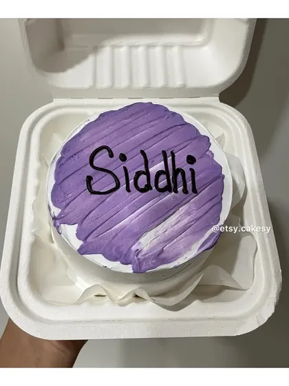 A purple brushstroke effect on a bento cake with a name.