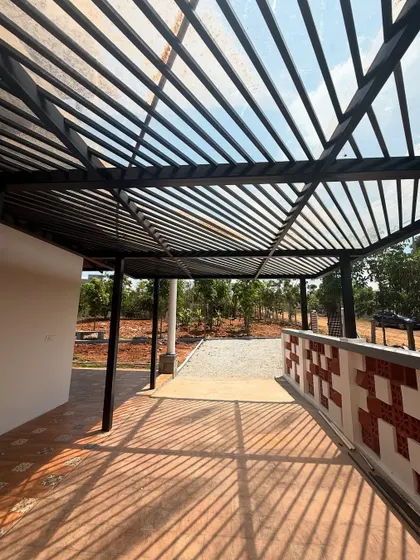 The slatted pergola structure provides a semi-shaded walkway, creating beautiful light and shadow patterns. This feature enhances the transition from the outdoors to the indoors, adding architectural interest.