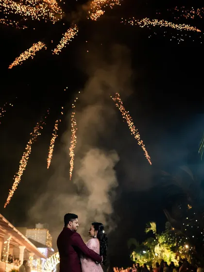 A magical reception photo of the couple under a sky full of fireworks. We specialize in capturing these spectacular, once-in-a-lifetime moments.