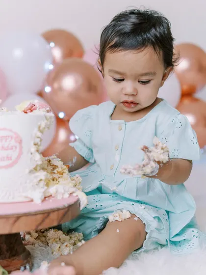 Look at that determination. A cake smash is a sensory adventure for a one-year-old, and I love capturing their focus and delight as they explore the textures and tastes of their very first birthday cake.