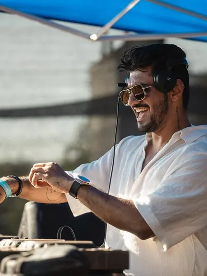 Adjusting my wristband, getting ready to drop the next track at Sunburn. Every detail matters when you're in the zone and building a set for a festival crowd.